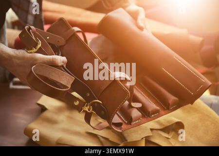 Handcrafted leather tool roll with brass hardware, artisan craftsmanship and quality material production, a person holds a brown leather tool roll wit Stock Photo