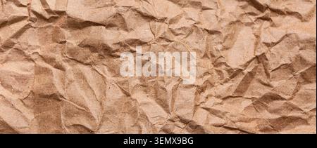 Crumpled brown kraft paper texture background, recycled packaging material, sustainable eco-friendly design element Stock Photo