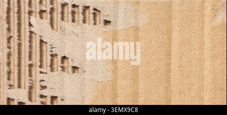 Recycled cardboard texture with torn edges and corrugated fluting, sustainable packaging material background Stock Photo