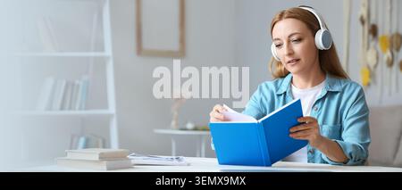 Focused woman in headphones reading book at home, e-learning and audio education concept, remote study and personal development Stock Photo