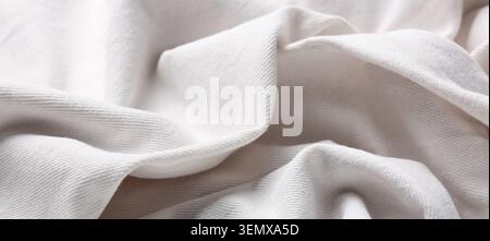 Soft white cotton fabric texture background with gentle folds and wrinkles, close-up view of natural textile material Stock Photo