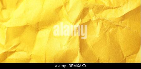 Bright yellow crumpled paper texture background with abstract folds and creases, rough surface detail for creative design Stock Photo