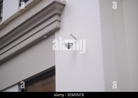 Security camera mounted on wall outside a building Stock Photo