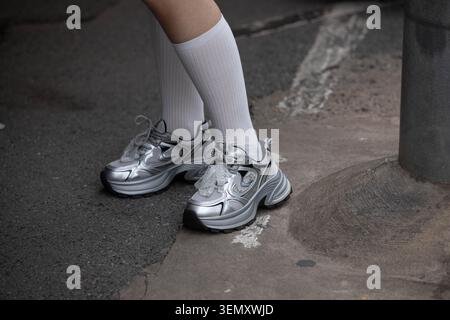 Female in silver sneakers standing at market, high angle view Stock Photo