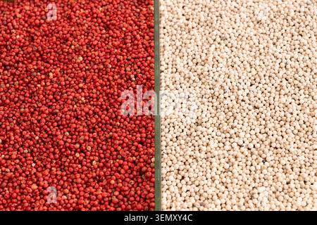 Contrast background pattern of pink and white peppercorns split in half. Top view texture of aromatic oriental spices, ideal for food design layout Stock Photo