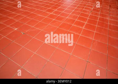 Wide abstract background view of red-orange square tiles forming a grid pattern across a wide ground Stock Photo