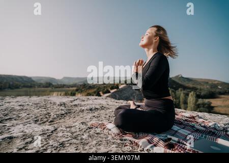 Woman Meditating on a Mountaintop Stock Photo