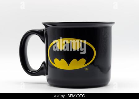 Black ceramic coffee mug featuring the yellow batman bat signal logo isolated on a white background. Stock Photo