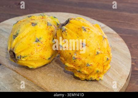 Close-up of a yellow dragon fruit (pitahaya) on a wooden background. Stock Photo
