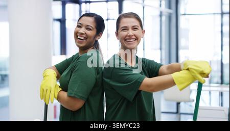 Janitor, women and portrait in office with team, hygiene service and smile for disinfection. Laugh, about us and cleaner group for sanitation Stock Photo