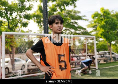 South East Asian Soccer Player Standing Near Goal On Outdoor Football Field Stock Photo