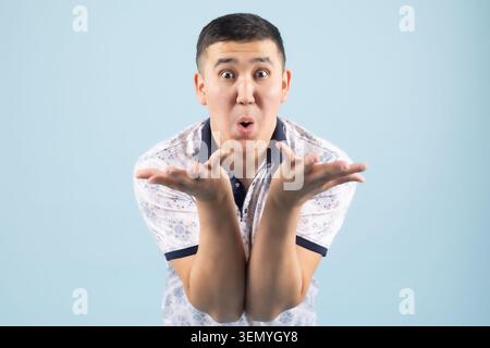 Handsome young expressive man posing emotionally in professional studio Stock Photo