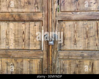 Old wooden gate with padlock. Lock pad locked on wooden door. Copy space Stock Photo