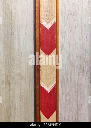 Decorative wooden board with pattern of red white arrows. It is used in interior design in country or farm style. Copy space Stock Photo