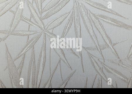 Minimalist bamboo leaf pattern on a textured fabric tapestry Stock Photo