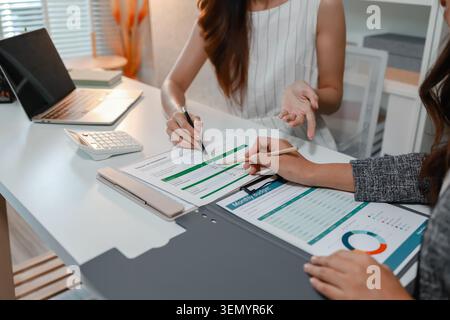 Business professionals reviewing financial reports, discussing budgets, analyzing performance data, calculating costs, and planning business strategie Stock Photo