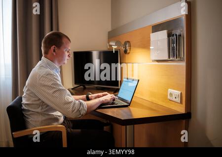 Man using laptop for business while traveling, focusing on remote work Stock Photo