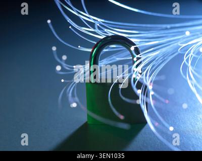 Padlock with glowing fiber optic strands representing data security and internet. Stock Photo