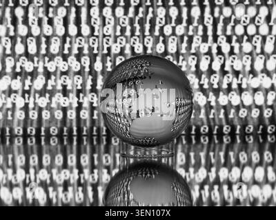 Glass globe with etched continents reflecting on binary code background in black and white. Stock Photo