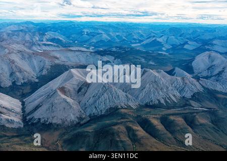 Majestic mountain range with rugged peaks and vast landscape under a cloudy sky. Stock Photo