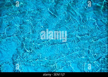 Close-up overhead view of swimming pool water with ripple and wave patterns creating intricate textures. Bright turquoise water with light reflections Stock Photo