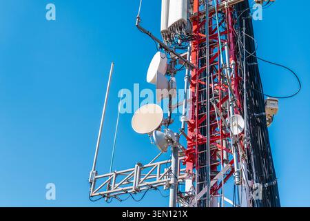 Cellular tower equipment with microwave antennas and communication hardware on telecom mast Stock Photo