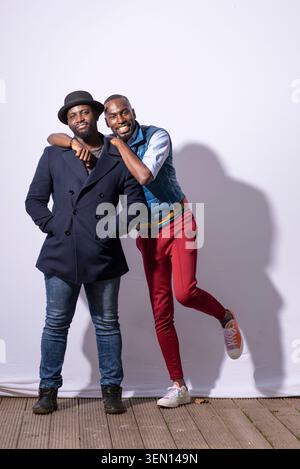 DeRay Mckesson and Derek Owusu stand close together at a creative event. They smile and share a light moment in a simple indoor space. The atmosphere Stock Photo