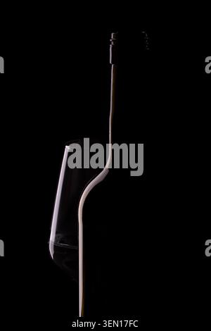 Minimalist low key silhouette of wine bottle and glass on dark black background, rim lighting photography Stock Photo