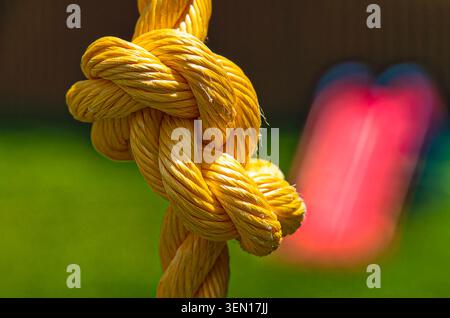 Yellow polypropylene rope with a complex knot Stock Photo