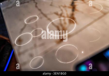 Ceiling lighting reflected onto a marble countertop Stock Photo