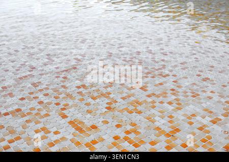 Water surface with colorful ceramic tiles seen on the bottom of a swimming pool. Stock Photo