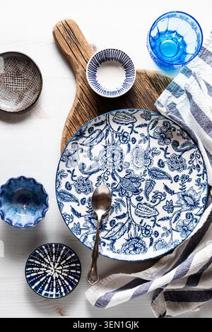 Beautiful blue decorated dishes on and around a wooden board. Stock Photo