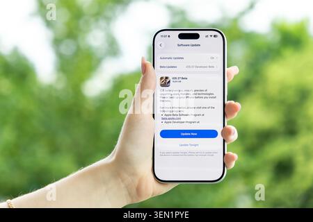 Poznan, Poland - June 9, 2026: User holding an Apple iPhone that shows an iOS 27 system update interface, highlighting a mobile technology upgrade and Stock Photo
