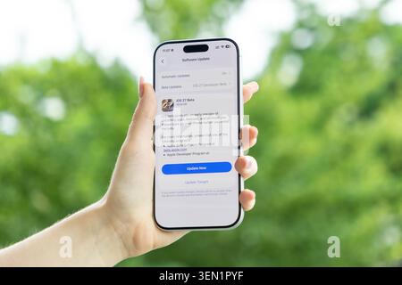 Poznan, Poland - June 9, 2026: Hand holding an Apple iPhone showing an iOS 27 system update notification on the display, symbolizing digital advanceme Stock Photo