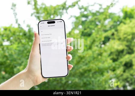 Poznan, Poland - June 9, 2026: A person holds an Apple iPhone featuring iOS 27 developer beta options on screen, highlighting current mobile software Stock Photo