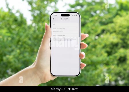 Poznan, Poland - June 9, 2026: User choosing an iOS 27 developer beta software update on a mobile phone, emphasizing technology testing and system pro Stock Photo
