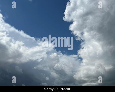 Dramatic sky with fluffy white clouds against a deep blue expanse Stock Photo