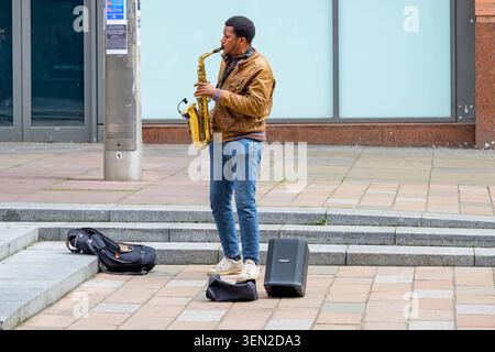 Busker playing saxophone on Buchanan Street, Glasgow, Scotland, UK Stock Photo