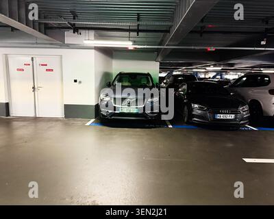Paris, France - May 14 2026: Parked Volvo and Audi cars in a dimly lit underground parking garage in Paris France. Stock Photo
