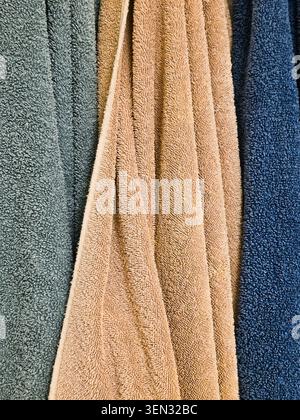 Soft Cotton Bath Towels Hanging in Bathroom Close Up With Textured Fabric Folds Stock Photo