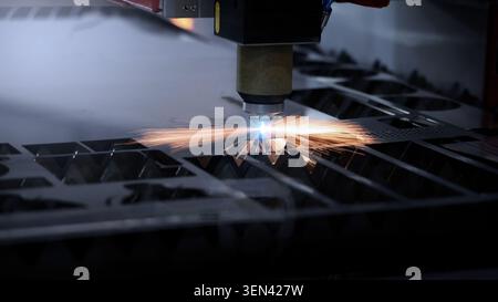 Laser cutting machine. High precision laser cutting robot processing sheet metal in factory. Ai automated CNC manufacturing technology creates intrica Stock Photo