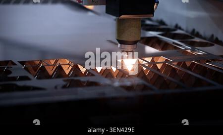 Laser cutting machine. High precision laser cutting robot processing sheet metal in factory. Ai automated CNC manufacturing technology creates intrica Stock Photo