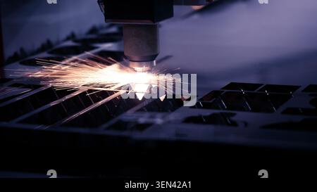 Laser cutting machine. High precision laser cutting robot processing sheet metal in factory. Ai automated CNC manufacturing technology creates intrica Stock Photo