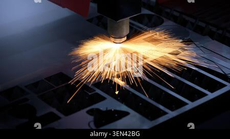 Laser cutting machine. High precision laser cutting robot processing sheet metal in factory. Ai automated CNC manufacturing technology creates intrica Stock Photo