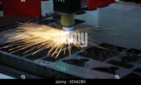 Laser cutting machine. High precision laser cutting robot processing sheet metal in factory. Ai automated CNC manufacturing technology creates intrica Stock Photo