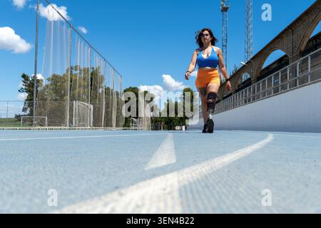 Amputee athlete walking on running track with prosthesis Stock Photo
