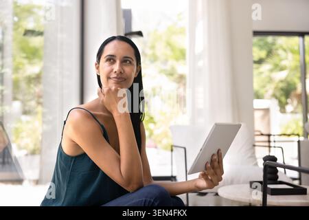 Pretty New-Zealander woman spend leisure on internet using digital tablet Stock Photo