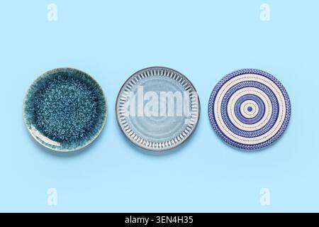 Three ceramic plates with unique textures and patterns on a light blue background, kitchenware and tableware design, this collection represents modern Stock Photo