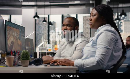 Team of designers developing digital 3D architecture model with virtual assets and software. Architect and worker uses interface to render apartment layout and prepare floor plan blueprints. Stock Photo