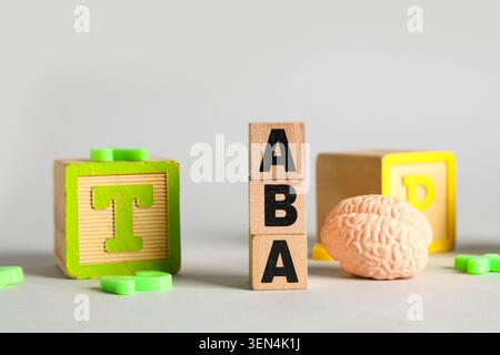 Aba therapy with wooden blocks and brain model for autism spectrum disorder treatment, the setup highlights the focus on behavioral analysis and cogni Stock Photo